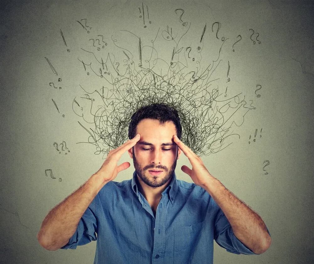 Man with a pained expression holding his head, surrounded by chaotic lines and question marks