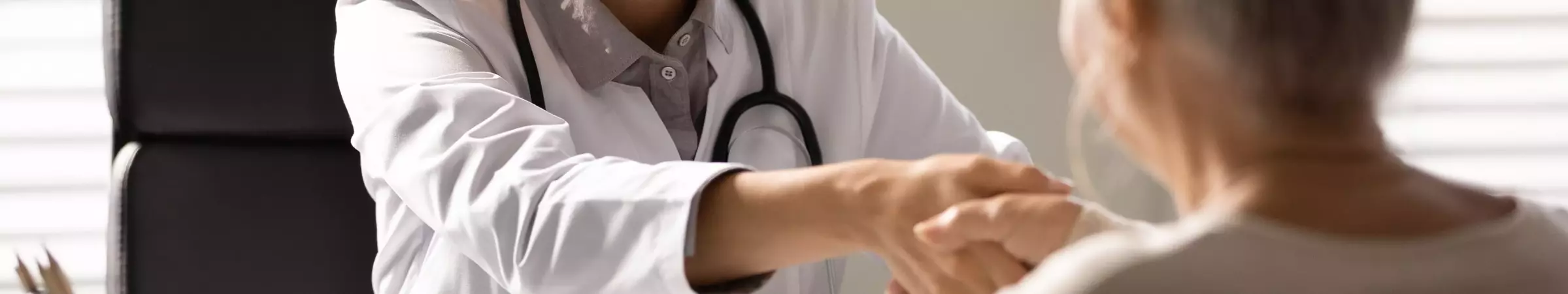 elderly woman shaking doctor's hand