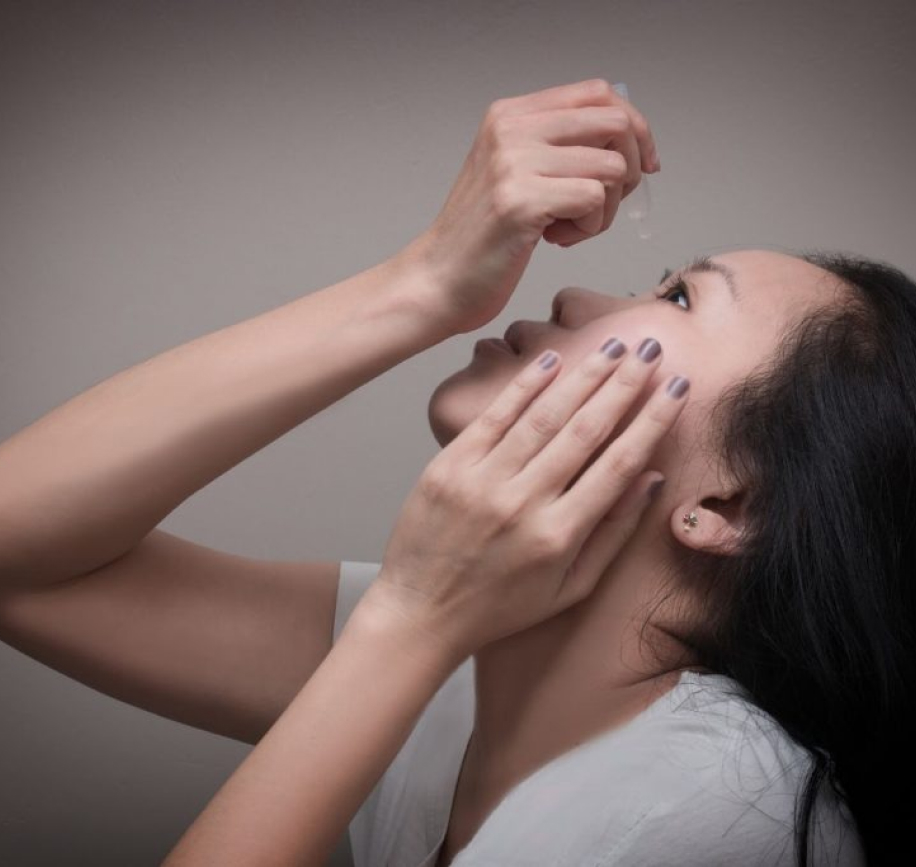 woman putting drops in eyes