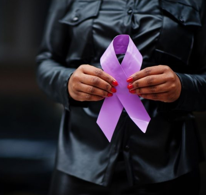woman holding purple ribbon