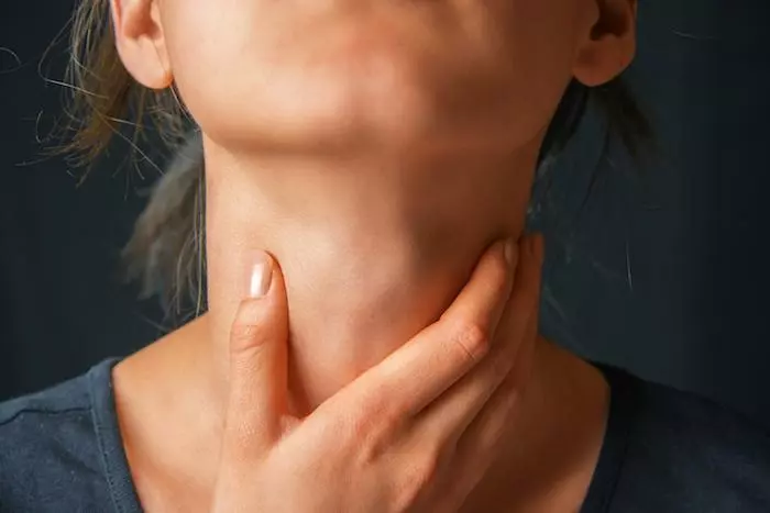 woman feeling throat
