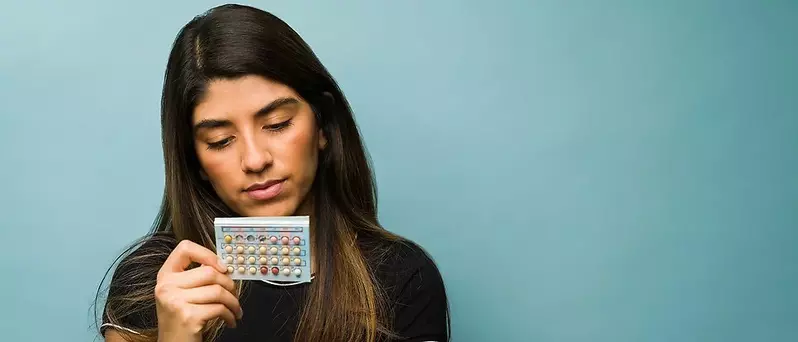 woman looking at pill pack